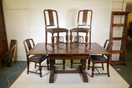 An early C20th oak draw leaf table and six chairs, with a carved frieze and raised on carved bulbous