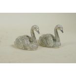 A pair of silver plated condiments in the form of swans, 2" long