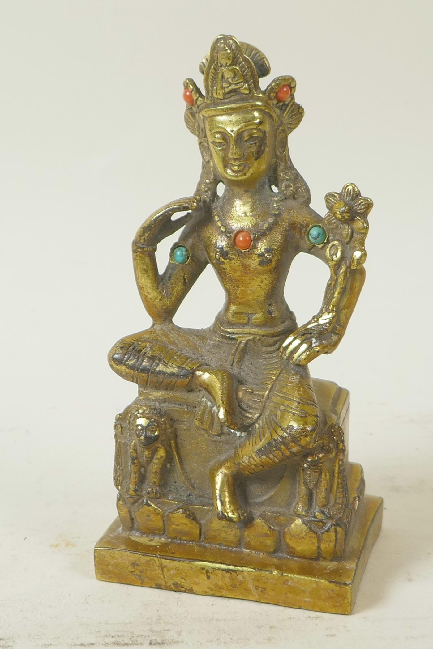 A Sino-Tibetan gilt brass figure of a seated deity embellished with turquoise and coral beads, 5½"