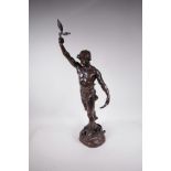A bronze figure of a victorious male athlete, standing on a naturalistic base with vanquished