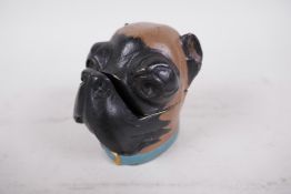 A cast metal inkwell in the form of a dog's head, cold painted in black and brown with a blue