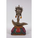 A Tibetan bronze kartika, the handle in the form of a wrathful deity, on a carved and painted
