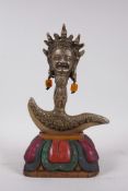 A Tibetan bronze kartika, the handle in the form of a wrathful deity, on a carved and painted