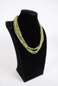 A four row green peridot gemstone necklace, with adjustable silver clasp, 18" long