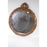 A vintage circular wall mirror with moulded acanthus leaf gilt frame, 25" diameter