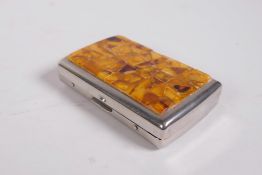 A plated metal cigarette box, the cover set with amber shards, 2" x 3½"