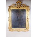 A C19th watergilt frame with heraldic crest and swag decoration, with an inset mirror, 27" x 38½"