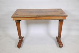 A blonde birch side table with ebonised decoration and brass mounts, raised on tapering end