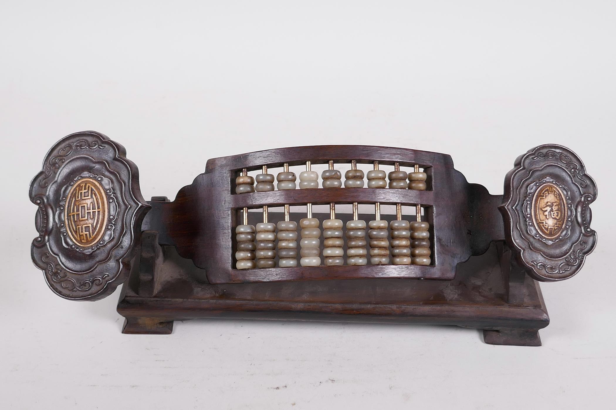 A Chinese carved hardwood abacus and stand in the form of a ruyi, with jade bead counters and - Image 2 of 4