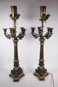 A pair of bronze and ormolu mounted five branch candelabra, converted to electric lamps with