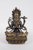 A Sino-Tibetan bronze figure of a four armed Buddha seated on a lotus throne, 8½" high