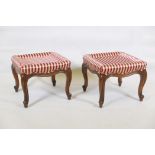 A pair of walnut footstools raised on cabriole supports with scroll ends, 17" x 17" x 14"