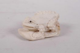 A carved bone netsuke in the form of a toad, 2" long