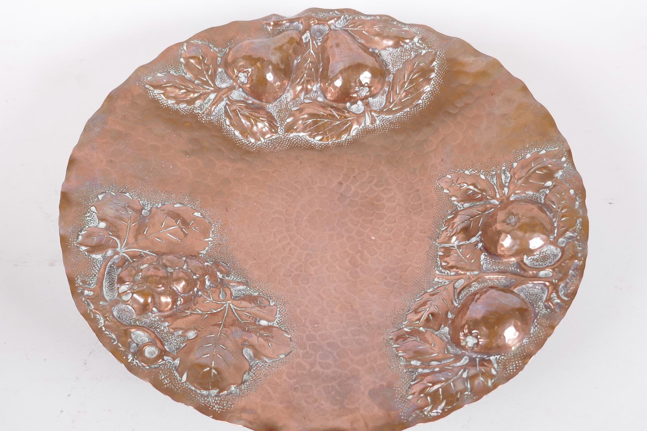 A beaten copper pedestal fruit dish with embossed apple, pear and grape decoration, 10¾" diameter - Image 2 of 4