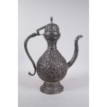 An Indo-Persian white metal coffee pot with repousse hand tooled decoration of birds amongst