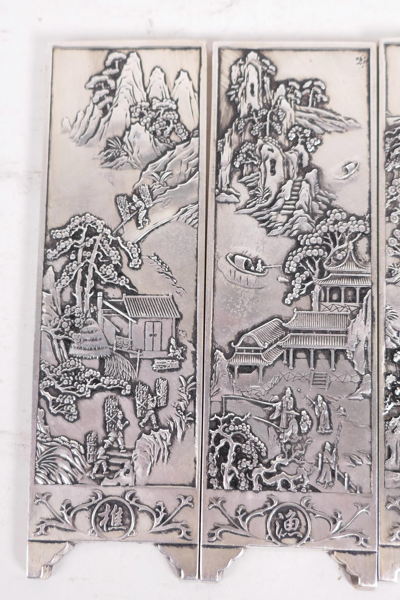 Four Chinese white metal scroll weights in the form of screen panels cast with landscape scenes, two - Image 2 of 4