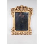A bevelled glass wall mirror in a pierced composition frame, 17" x 24" overall
