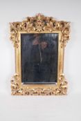 A bevelled glass wall mirror in a pierced composition frame, 17" x 24" overall