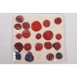 A collection of antique wax seals mounted on paper