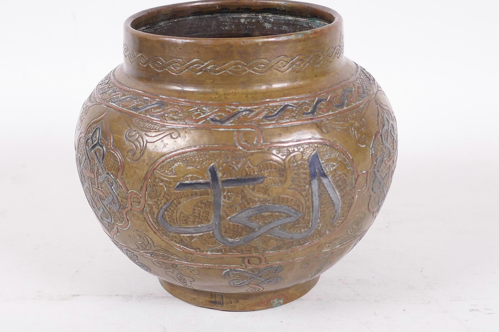 An antique Islamic brass pot decorated with inlaid copper and wire on an engraved background with - Image 4 of 4