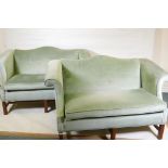 A pair of camel back settees with scroll arms, raised on square moulded supports united by
