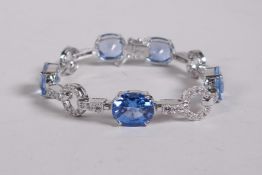 A silver, cubic zirconium and blue topaz set line bracelet, 6" long