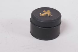 A Wedgwood basalt-ware famille verte pill box, the cover with raised gilded griffin, 1¼" high