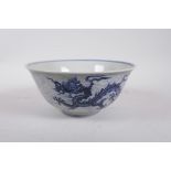 A Chinese Ming style porcelain bowl decorated with a dragon in flight, 6 character mark to base, 8½"