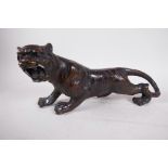 An Oriental bronze figure of a roaring tiger, 13" long