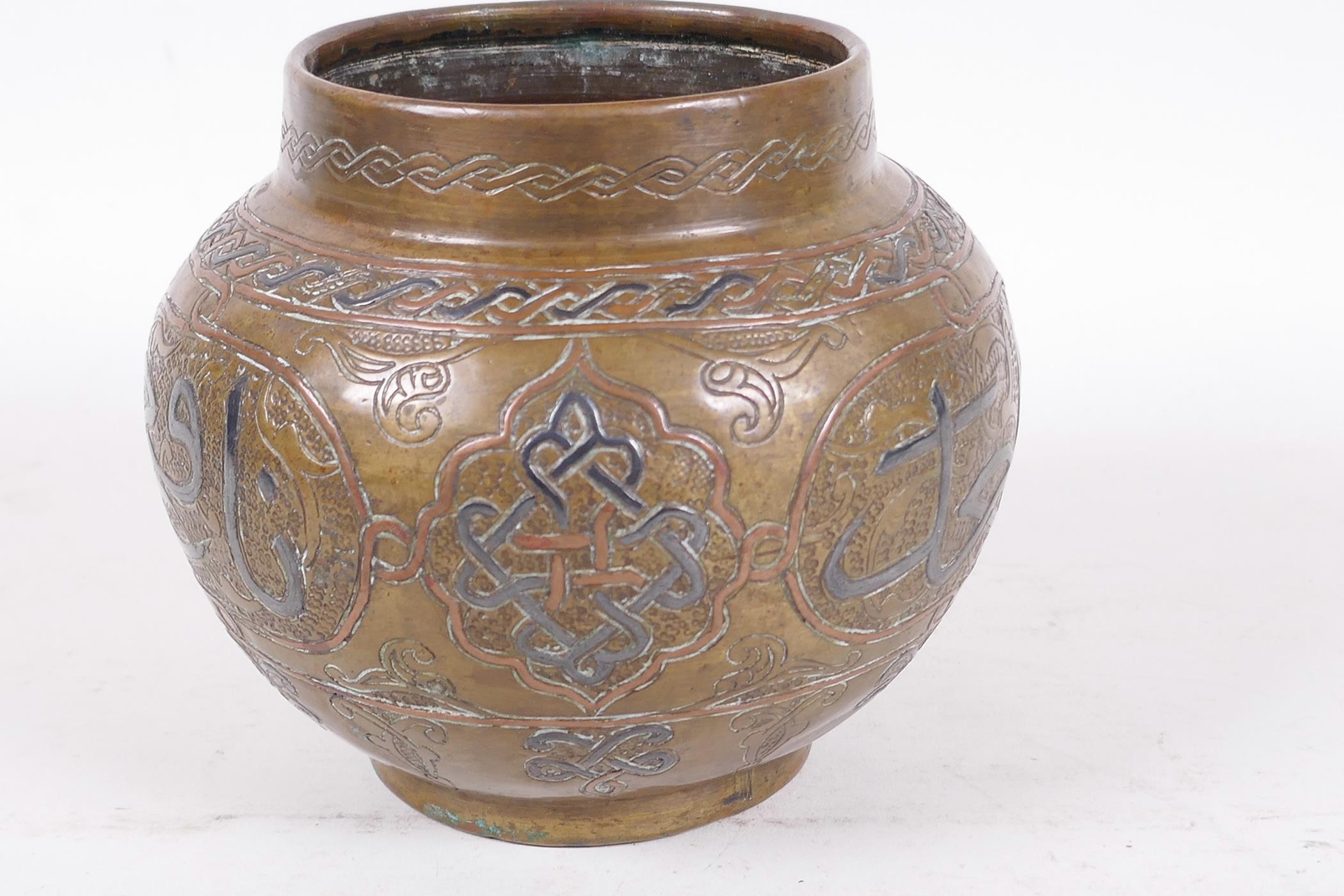 An antique Islamic brass pot decorated with inlaid copper and wire on an engraved background with - Image 3 of 4