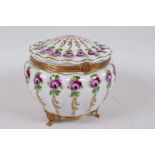 A Limoges porcelain casket with ribbed design, painted with roses and gilt highlights on a gilt base