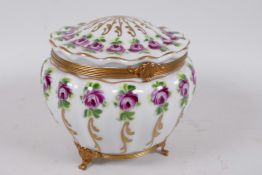 A Limoges porcelain casket with ribbed design, painted with roses and gilt highlights on a gilt base