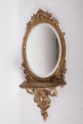An antique gilt composition oval bracket mirror with swag decoration, 28" x 12"
