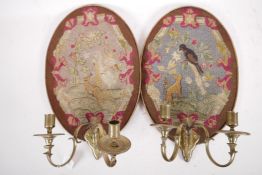 A pair of C19th two branch wall sconces with tapestry backs depicting a dog and bird in a tree,