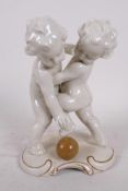A Continental porcelain figure of two nude boys wrestling over a ball, 7½" high