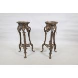 A pair of painted metal urn stands raised on shaped supports with paw feet, 10" x 28" high