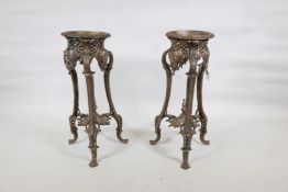 A pair of painted metal urn stands raised on shaped supports with paw feet, 10" x 28" high