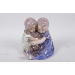 A Royal Copenhagen porcelain figure of two young children with a puppy, 6" high