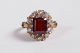 An 18ct gold lady's dress ring set with a garnet encircled by ten diamonds, approximate size 'M/