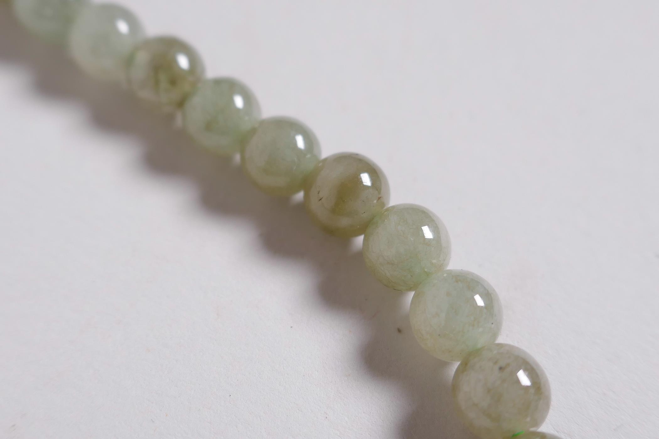 A Chinese celadon jade necklace, 27" long - Image 4 of 4