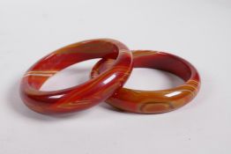 A pair of red banded agate bangles, 3" diameter