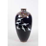 A Japanese Meiji period (1868-1912) enamel vase depicting red crowned cranes in flight,