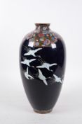 A Japanese Meiji period (1868-1912) enamel vase depicting red crowned cranes in flight,