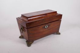 A Regency brass inlaid rosewood two division tea caddy with central mixing bowl, raised on paw feet,