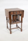 A Waring & Gillow oak dropleaf side table incorporating a revolving bookcase, raised on