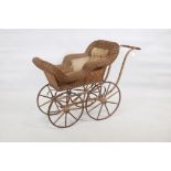 A vintage cane and wood frame child's pram, with steel rimmed wheels, 41" x 19" x 29"