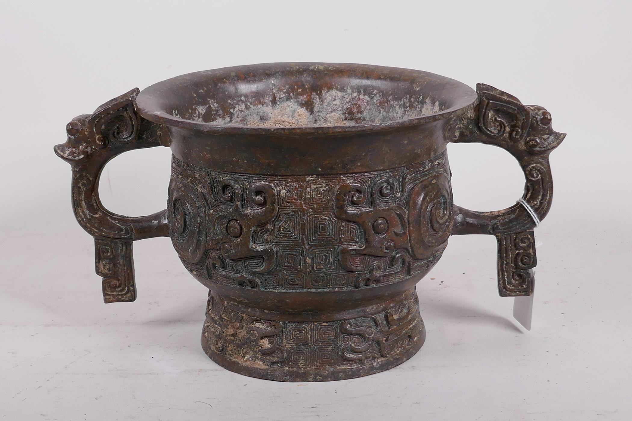 A Chinese bronze two handled censer with raised archaic style decoration, 12" x 6" high