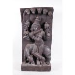 An Indian hardwood carving depicting a deity playing the flute under a fire headed serpent, 10" x