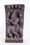 An Indian hardwood carving depicting a deity playing the flute under a fire headed serpent, 10" x