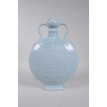 A Chinese blue glazed porcelain two handled moon flask with underglaze carp and symbol decoration,